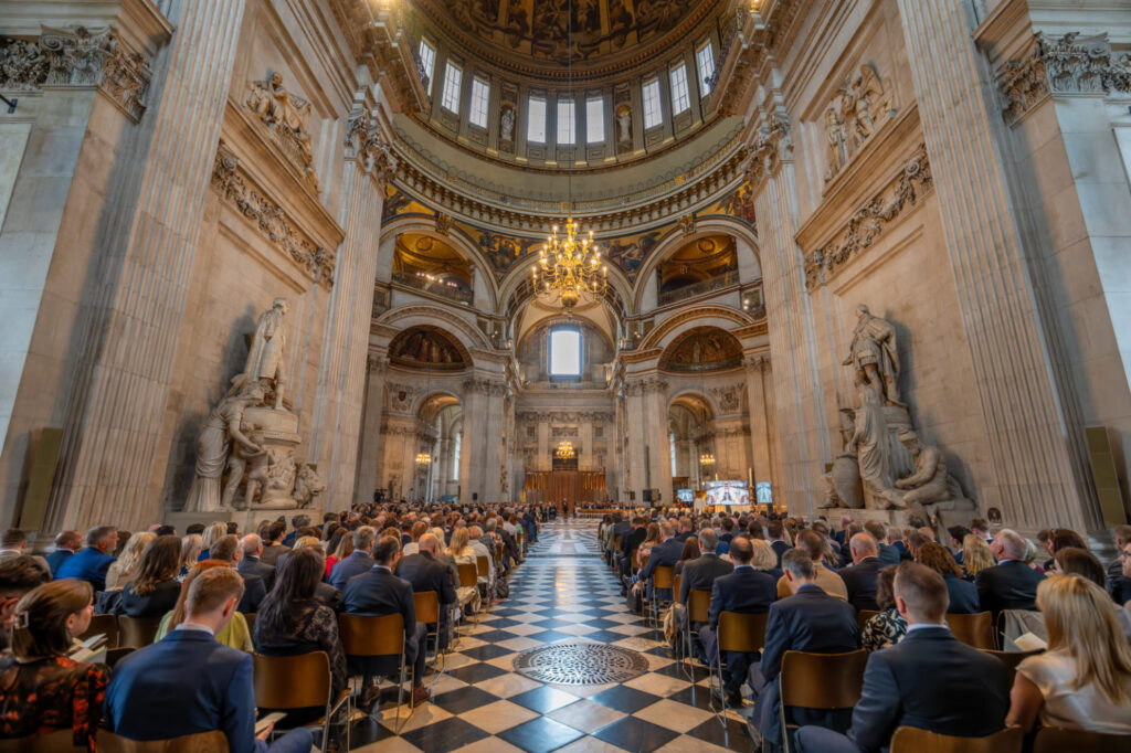 Shot of the walkway through the center of St Paul's Cathedral with attendees sat on chairs either side