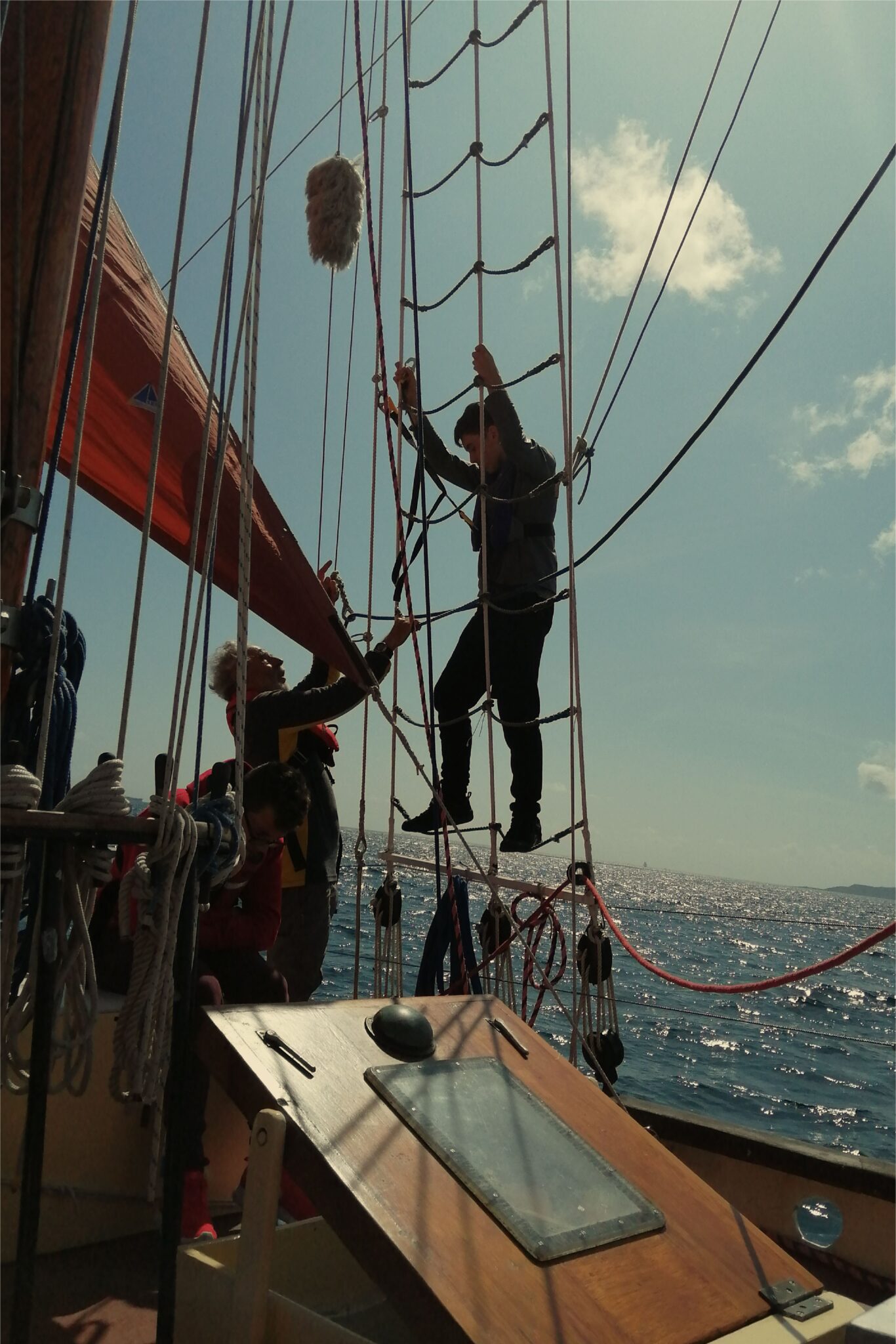 man helping boy climb a sail